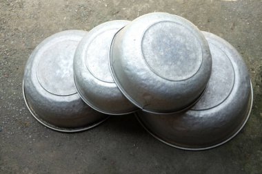 Beton zeminde yıkanmak için alüminyum leğen.