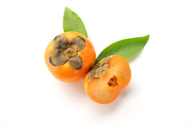 Taze olgun portakal hurması. Yarım meyve ile kesilmiş. Beyaz bir arka planda izole edilmiş.