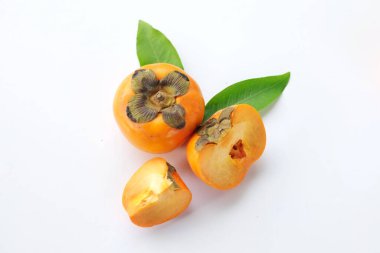 Taze olgun portakal hurması. Yarım meyve ile kesilmiş. Beyaz bir arka planda izole edilmiş.