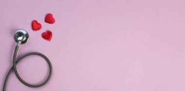 Pembe arka planda bir steteskop ve kırmızı kalpler sağlık hizmetleri kavramının fotokopisi.