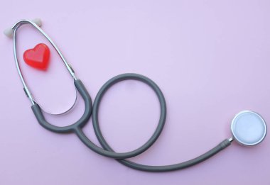 Stethoscope and red hearts on a purple pastel  background .Health care concept.