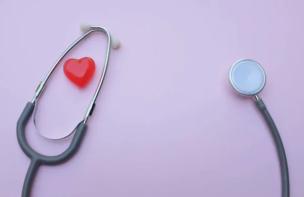 Stethoscope and red hearts on a purple pastel  background .Health care concept.