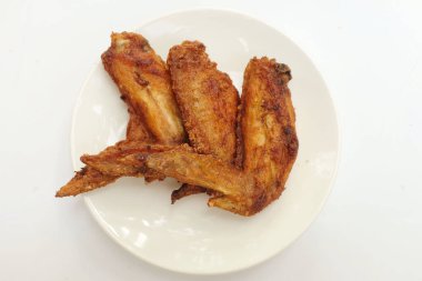 Kızarmış tavuk kanatlarını beyaz tabakta kapat. Beyaz bir mezarlıkta izole et.