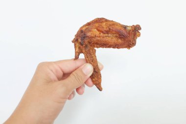 Beyaz bir arka planda kızarmış tavuk kanadı tutan bir kadın elini kapatır.