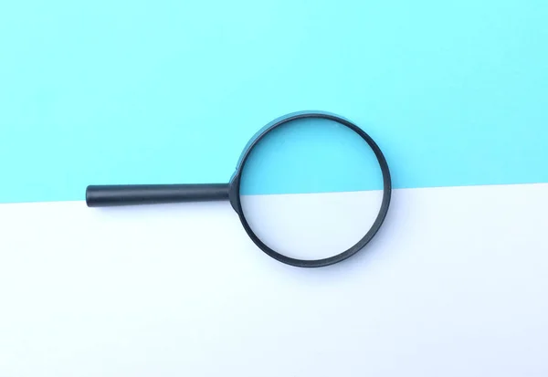 Black Magnifying Glass Colored Paper White Blue Geometric Shapes Backgrund — Foto Stock