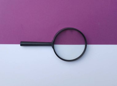 Siyah renkli kağıt üzerinde büyüteç beyaz ve mor geometrik şekiller geri grund.