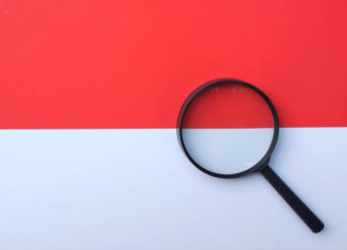 İzole edilmiş kırmızı ve beyaz arkaplanda büyüteç