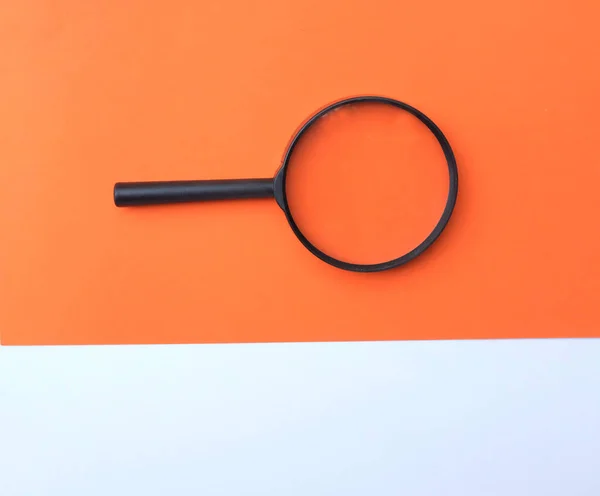 Black Magnifying Glass Colored Paper White Orange Geometric Shapes Backgrund — ストック写真