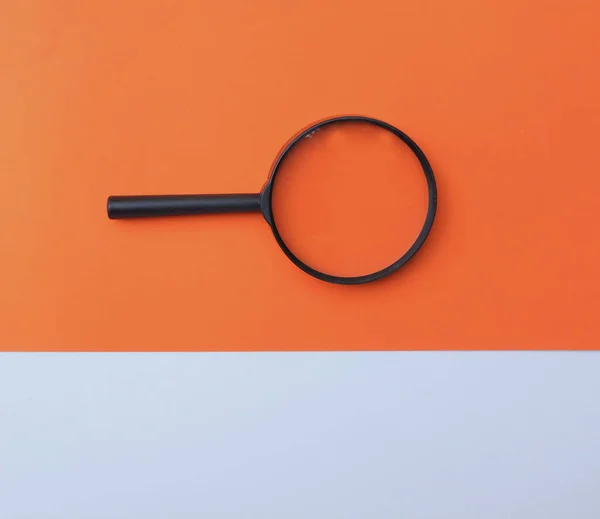 Nero Una Lente Ingrandimento Carta Colorata Bianco Arancione Forme Geometriche — Foto Stock