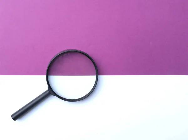 彩色纸上的黑色放大镜 白色和紫色的几何图形背景 — 图库照片
