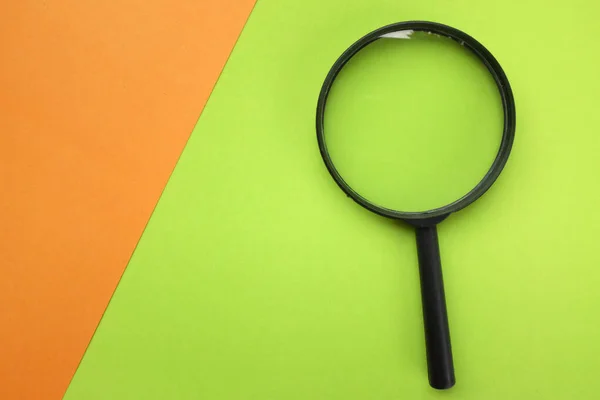 Black Magnifying Glass Colored Paper Orange Green Geometric Shapes Backgrund — Fotografia de Stock