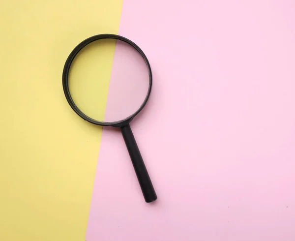 Black Magnifying Glass Pink Yellow Background Used Searching Expanding Books — Foto Stock