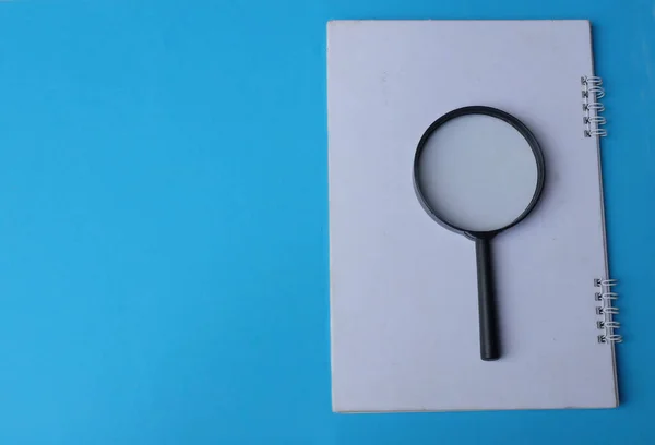 magnifying glass search symbol on notepads isolate a blue background