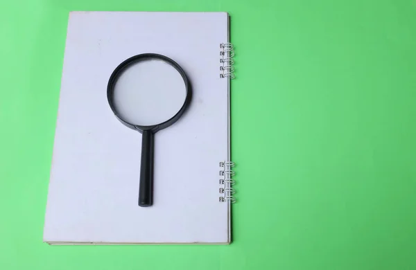 magnifying glass search symbol on notepads isolate a green background