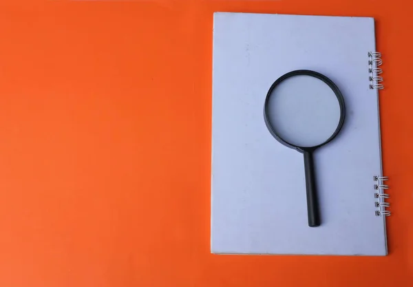 magnifying glass search symbol on  notepads isolate a orange background