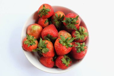 Üst manzara, beyaz bir arkaplanda izole edilmiş taze sulu çilekler.