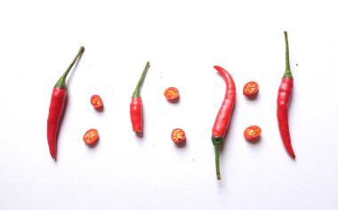 Olgun kırmızı kırmızı biberler, beyaz arka planda izole edilmiş sebzeler. Yemek malzemeleri.