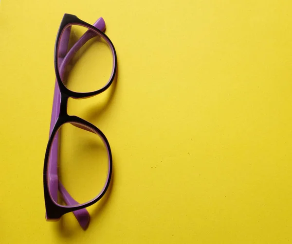 copy space a purple framed eyeglasses isolate on a yellow background