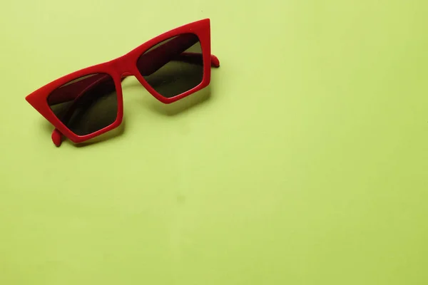 Espaço Cópia Uma Moldura Vermelha Óculos Sol Isolar Fundo Verde — Fotografia de Stock