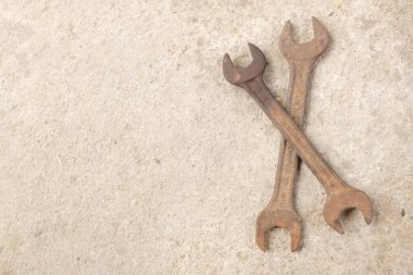 copy space a Lots of rusty old wrenches on the cement floor.