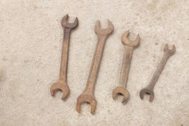 Beton zeminde bir sürü paslı eski İngiliz anahtarı var..