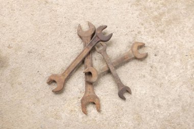 Beton zeminde bir sürü paslı eski İngiliz anahtarı var..