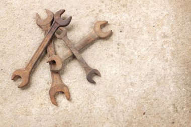 copy space a Lots of rusty old wrenches on the cement floor.