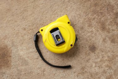 flat lay and top view one a yellow tape measure on cement background