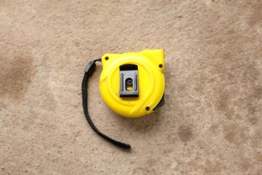 flat lay and top view one a yellow tape measure on cement background