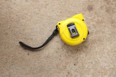 flat lay and top view one a yellow tape measure on cement background