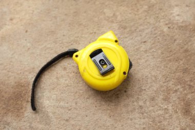 flat lay and top view one a yellow tape measure on cement background