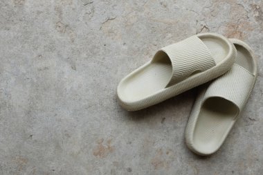 copy space a pair of slides with an open toe pillow isolated on a on cement floor background. Women's fashion. Women's summer footwear. 