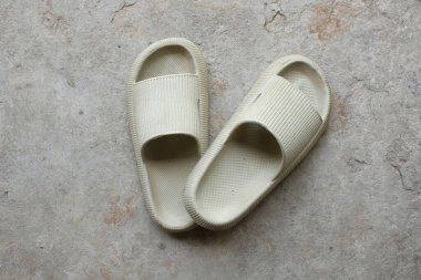top view and flat lay a pair of slides with an open toe pillow isolated on a on cement floor background. Women's fashion. Women's summer footwear. 