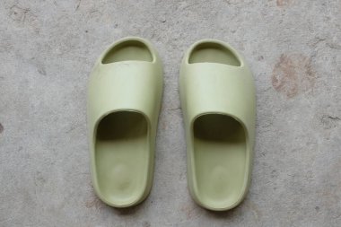 top view and flat lay a pair of slides with an open toe pillow isolated on a on cement floor background. Women's fashion. Women's summer footwear. 