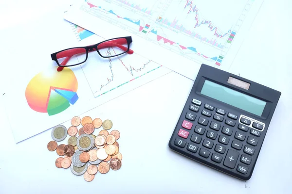 flat lay a glasses, money, calculator and chart or graph on office desk table.Finance and business concept.