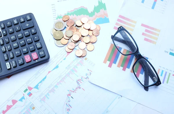 close up a glasses, money, calculator and chart or graph on office desk table.Finance and business concept.
