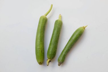 top view and close up fresh sponge gourd (luffa aegyptiaca) is family plant cucurbitaceae is vegetable herb and is short lived ivy isolated on white background.