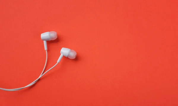 white music headphones ,earphones with headset on isolated bright orange background. Music concept. copy space