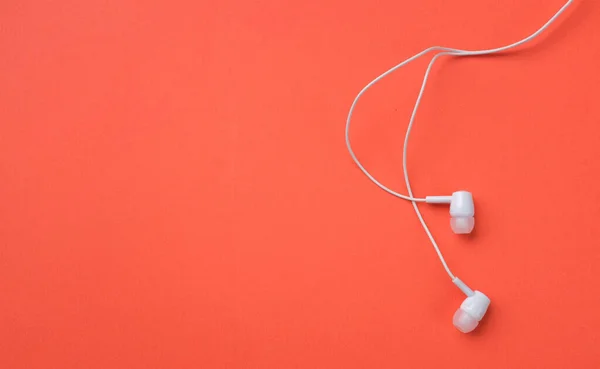 white music headphones ,earphones with headset on isolated bright orange background. Music concept. copy space