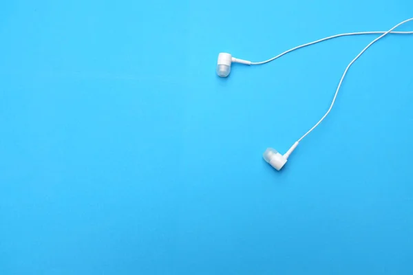 white music headphones ,earphones with headset on isolated bright blue background. Music concept. copy space