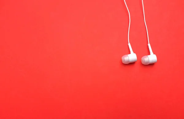 white music headphones ,earphones with headset on isolated bright red background. Music concept. Top view