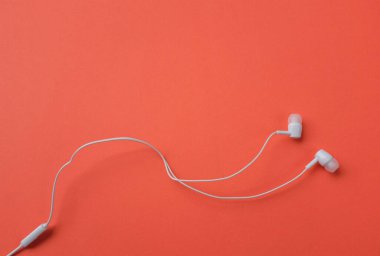 Yukarıdaki beyaz kulaklıklardan, kulaklıklardan, kulaklıklardan izole edilmiş turuncu parlak arka plandan.