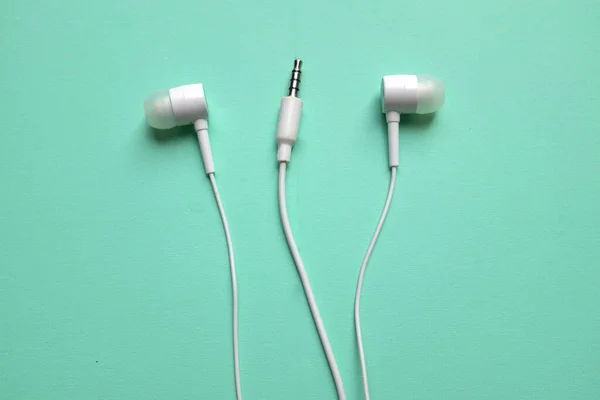 Close Λευκά Ακουστικά Ακουστικά Ακουστικά Ακουστικά Απομονωμένο Πράσινο Παστέλ Φόντο — Φωτογραφία Αρχείου