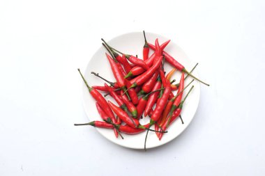 Beyaz seramik tabakta taze kırmızı biber. Beyaz arka planda izole edilmiş.