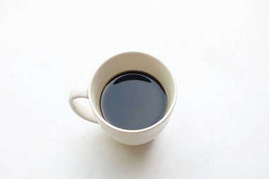 Bir kahve sıcak americano, cam beyaz bir fincanda sabahları uyanık ve dinlenmiş kalmalarına yardımcı olur ve beyaz arka planda izole bir şekilde çalışmaya hazırdır.