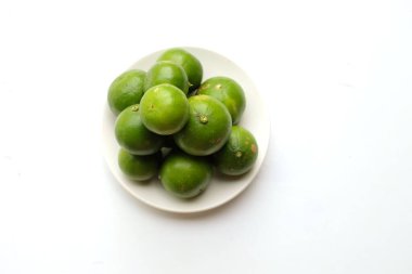 Üst görünüm taze kireç, beyaz tabakta limon stüdyoda beyaz bir arkaplanda izole edilmiş.