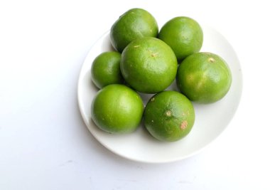 Üst görünüm taze kireç, beyaz tabakta limon stüdyoda beyaz bir arkaplanda izole edilmiş.