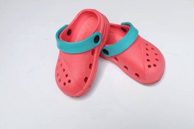 Üst ve düz beyaz arka planda izole edilmiş renkli çocuk ayakkabıları vardı. Çocukların moda terlikleri.