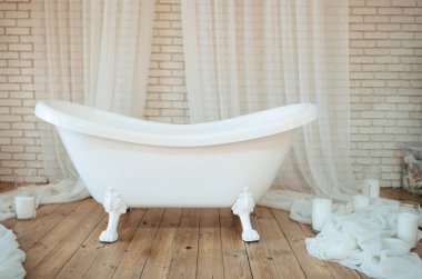 Beautiful retro bath on wooden floor with many white candle. Relax spa time. Selective focus 