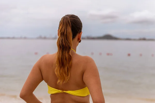 Vista posteriore della donna latina in piedi in bikini in spiaggia — Foto Stock